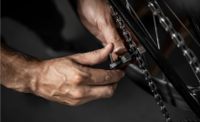 Mani che puliscono la catena di una bici