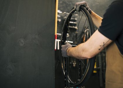 Meccanico lavora con le ruote di una bicicletta
