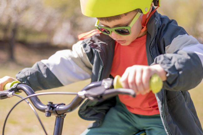 bambino con casco guida una bicicletta